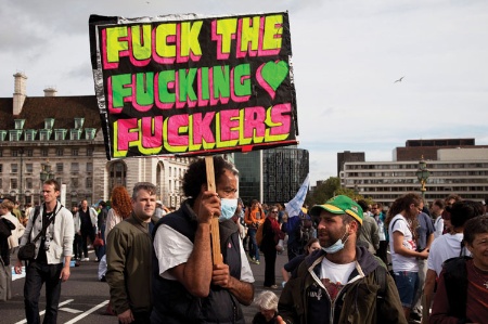 Demonstrator holding expletive-riddled placard