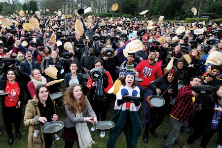 Crowd of students flipping pancakes