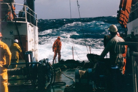 Sailors on boat in stormy sea