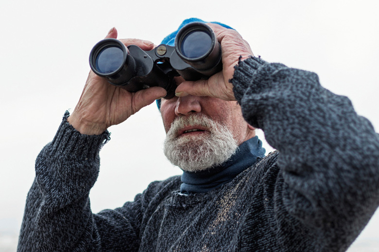 Man looking through binoculars