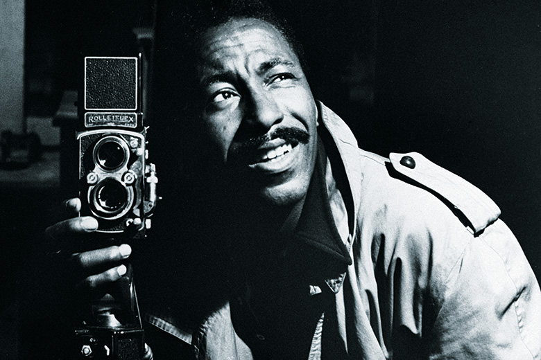 Photographer Gordon Parks posing with camera