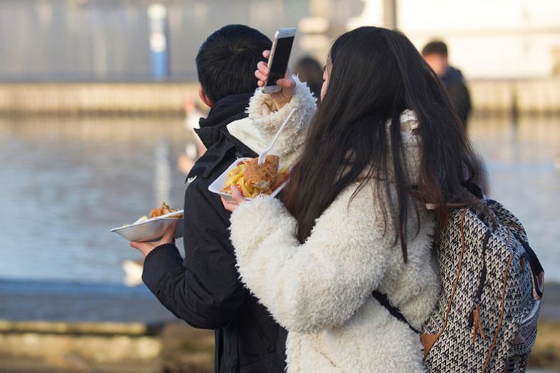 woman eating chips and taking a photo