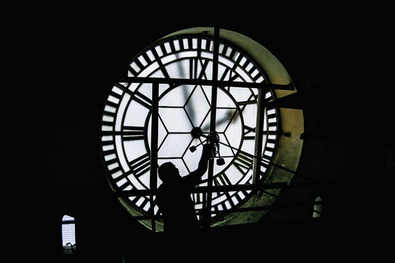 person fixing giant clock