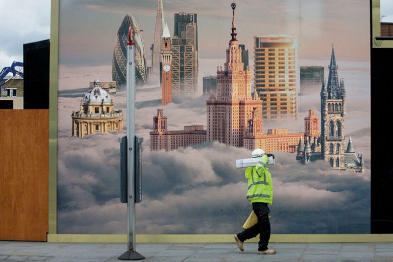 man walking past buildings