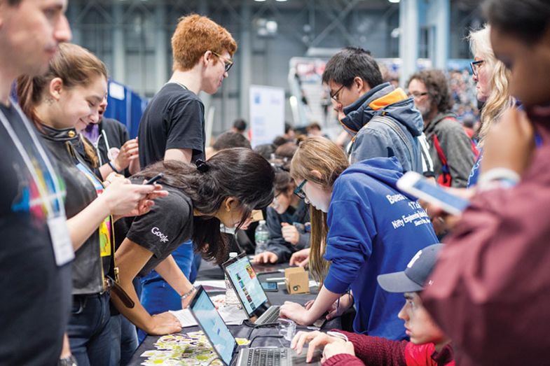 Workers from Google interact with visitors at a Career Expo