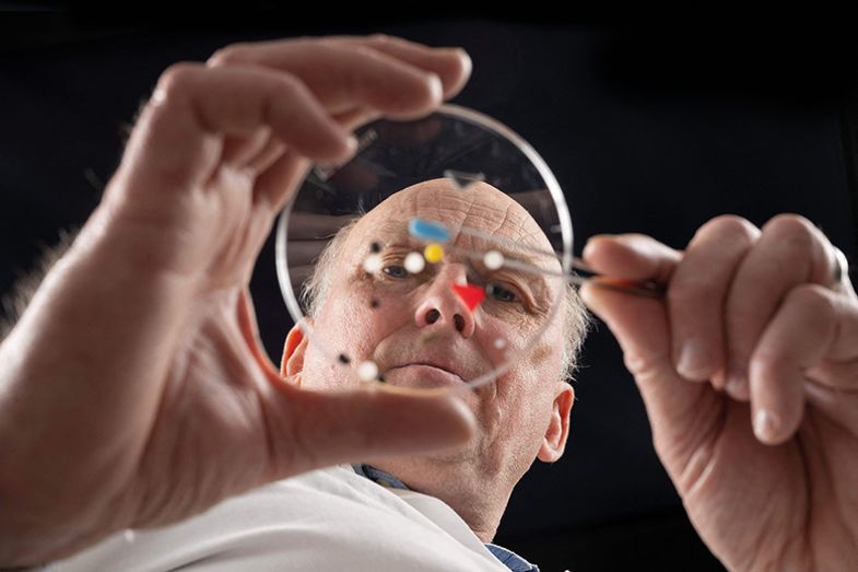 Scientist with petri dish from below