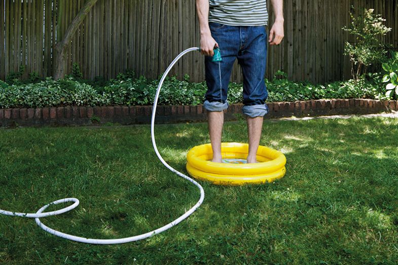 Man fills tiny paddling pool