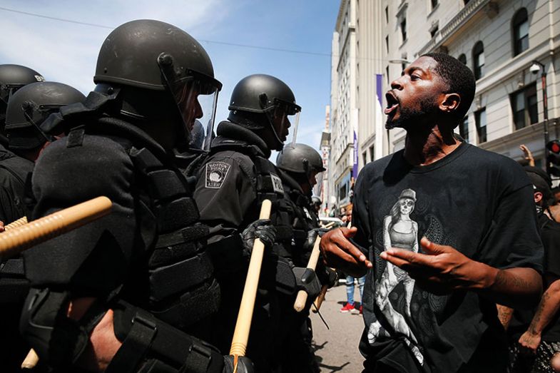 Man in front of riot police during rally in solidarity with Charlottesville, US