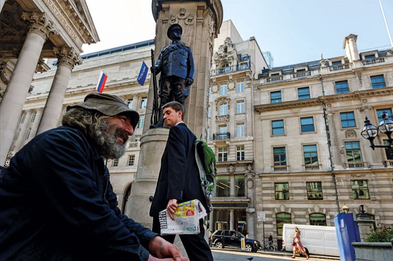 Man in suit walking past homeless man