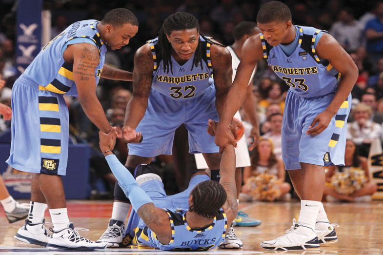  Jae Crowder #32 and Jimmy Butler #33 of the Marquette Golden Eagles help teammate Dwight Buycks #23 up off the court late in the second half during the second round of the 2011 Big East Men's Basketball Tournament 