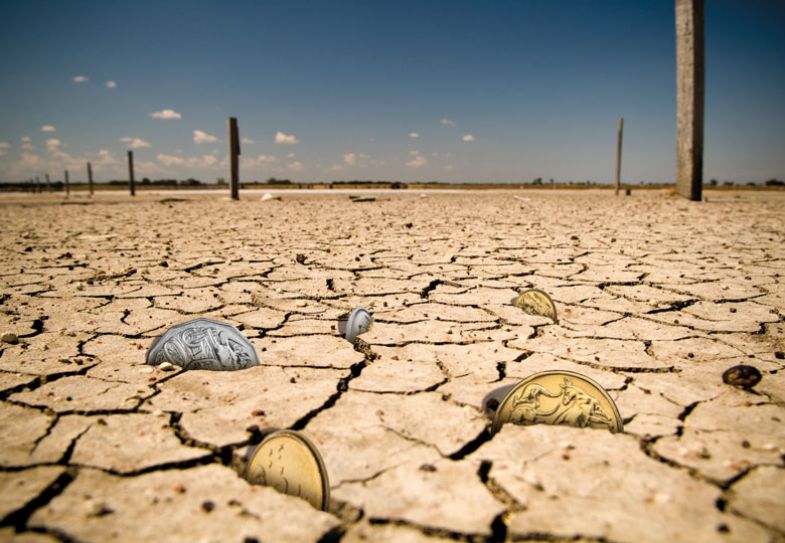 concept of coins deep between cracks in the Earth to illustrate the cost of living crisis