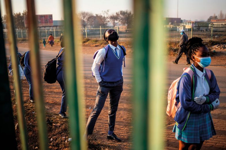 Pupils at the Winnie Mandela Secondary School wait in line outside the school premises before classes resume in the Tembisa township, Ekurhuleni