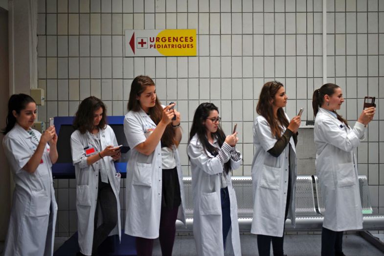 Medical staff taking photos with their phones as a metaphor for Computer says no phones