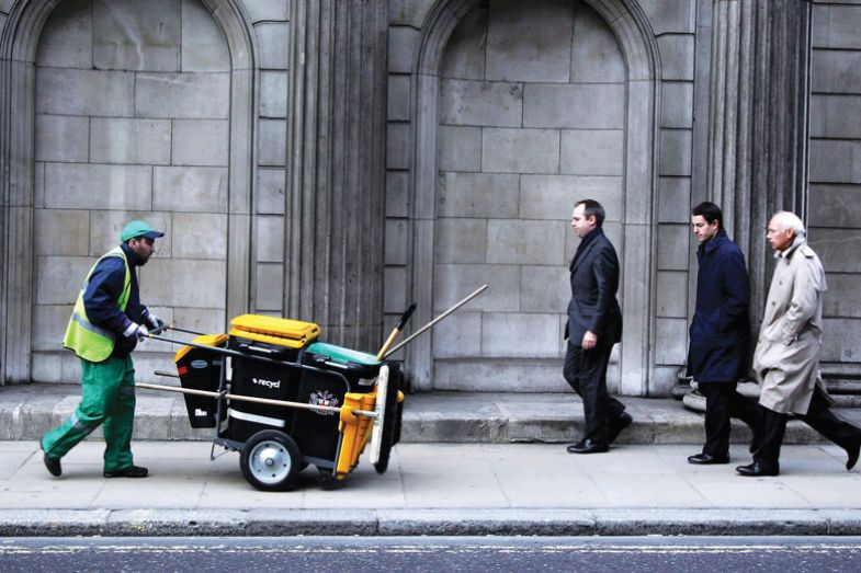 Man pushing dust cart in city for book, The Sum of Us: What Racism Costs Everyone and How We Can Prosper Together