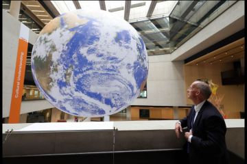 A man looks at a giant globe