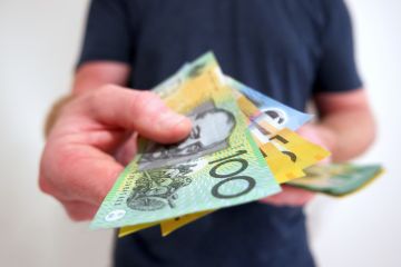 A man hands out Australian dollars