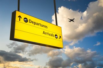 A plane flying over a departures and arrivals sign, symbolising internationalisation