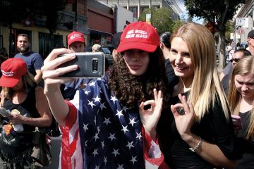 Women draped in stars and stripes take selfie