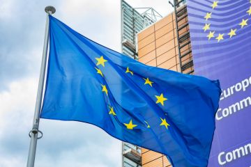 European Union flag in front of the Berlaymont building, headquarters of European Commission.