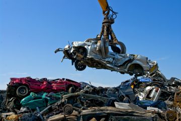 Crane picking up a car in a junkyard