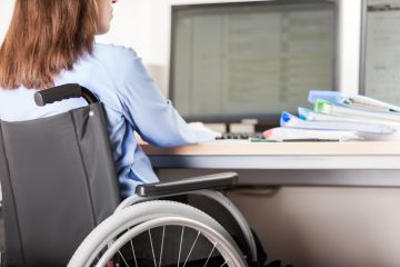 A wheelchair users works at a computer