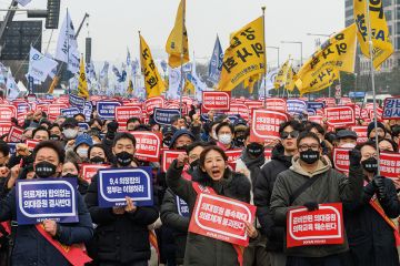 South Korean doctors hold placards saying "Opposition to the increase in medical schools" to illustrate Row over doctors’ training thwarts Korean president