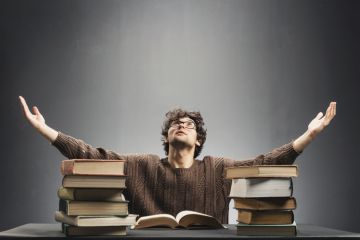 A man with a pile of books, symbolising Lifelong learning