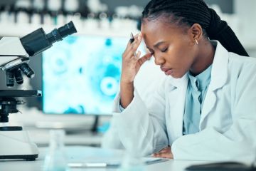 A postdoc holding her head