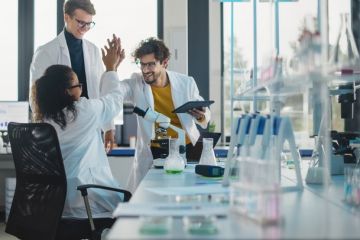 Scientists high-fiving, symbolising research culture