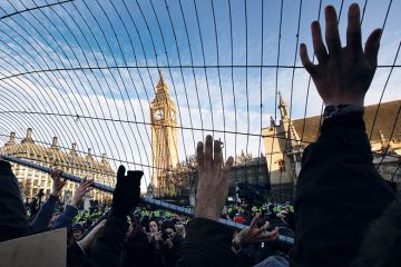 Student fees protesters attempt to throw a fence at police in Parliament Square in December 2010 in London