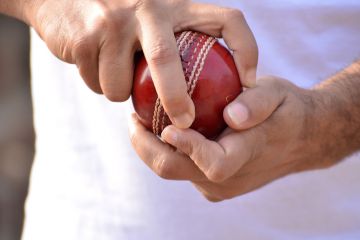 A spin bowler’s hands, holding the ball