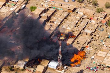 A building on fire in the Sudan war