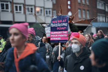 Montage: strikers march with a sign on a stick, with broken glass overlaying the image