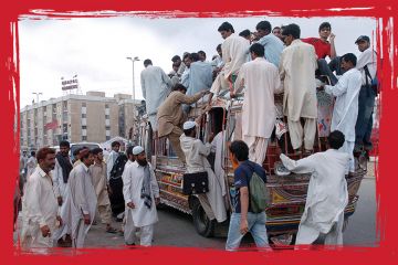 Pakistani commuters climb on a crowded public transport vehicle in Karachi, to illustrate 'State of emergency'