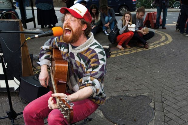 A man playing a guitar and singing