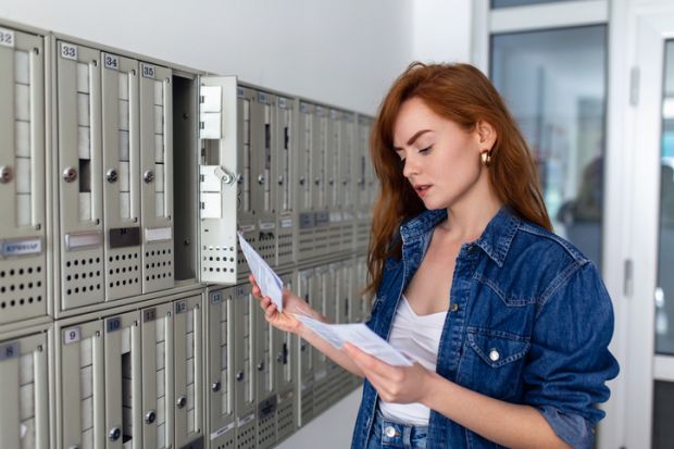 A young woman looks at a university admissions letter