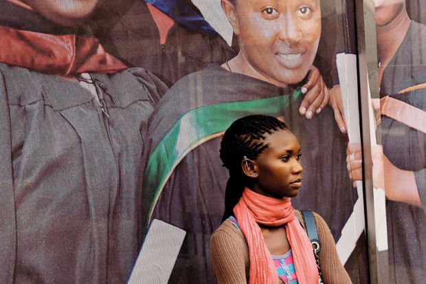 African woman standing in front of university sign