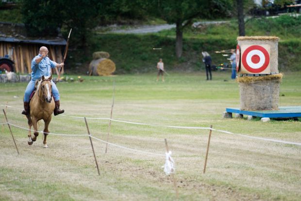 Archer firing arrow from horseback