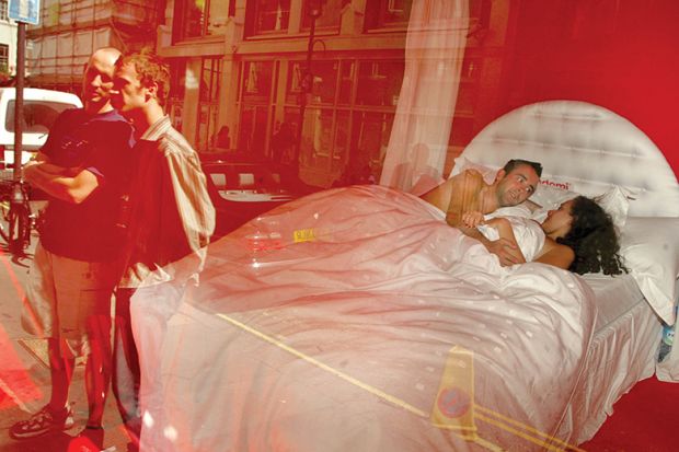 Max Whatley and Meg Zakreta are watched by pedestrians as they lie in bed in a public artwork known as “No Inhibition” in the window of the Blink Gallery, August 29, 2002, in London, England, illustrating review of book On Getting Off: Sex and Philosophy 