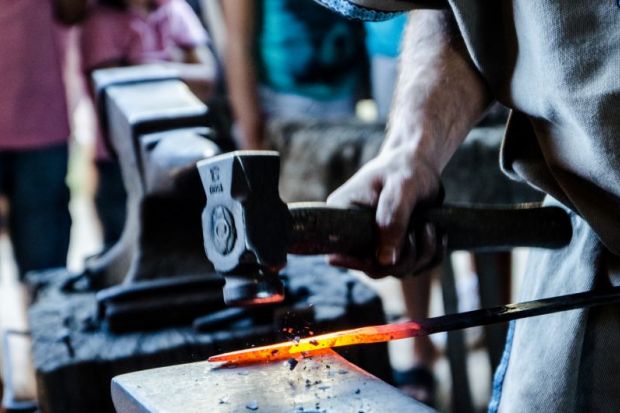 Blacksmith hammering a sword