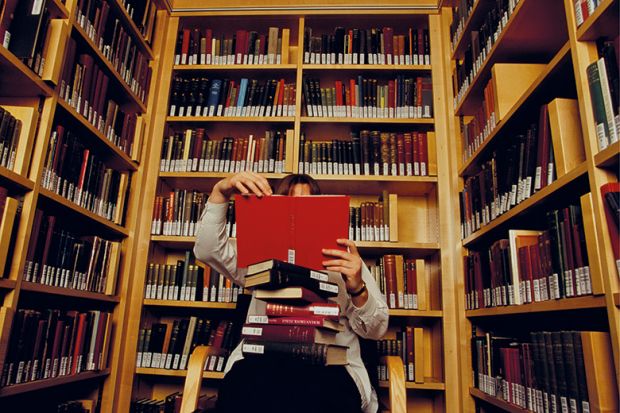 Person reading books in library