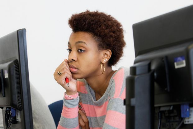 Bored young woman looking at computer screen