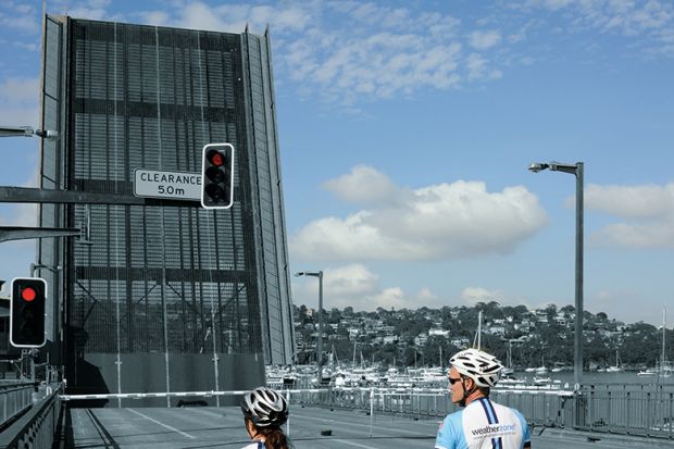 Two cyclists waiting at bridge 