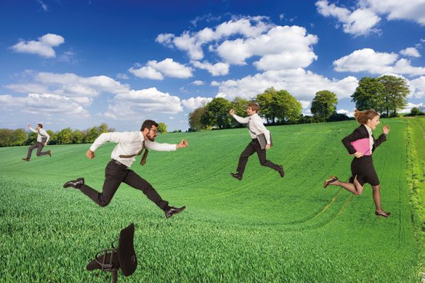 Business people running through field