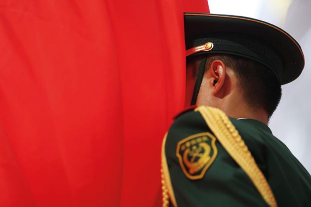 Chinese soldier with face in flag of China, Beijing, 2015