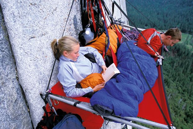 Woman and man hanging on cliff