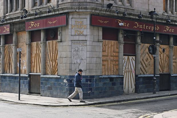 Man walks past a vacant building