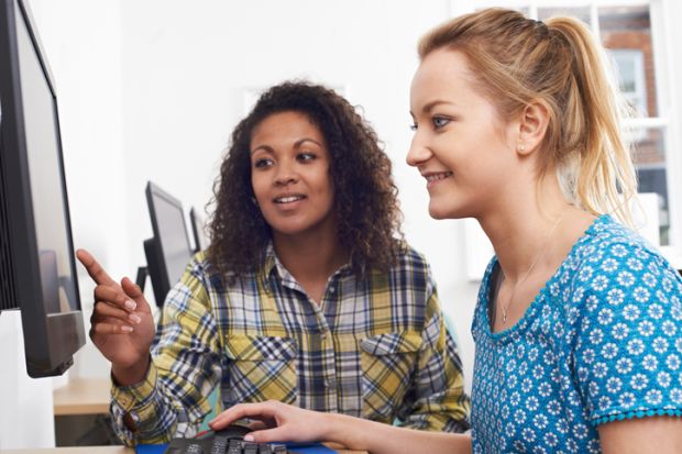 A woman training another on a computer