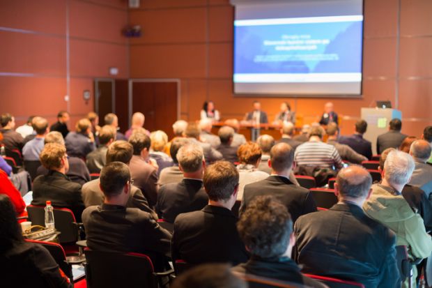 Conference audience illustrating return to in-person events via  hybrid mode