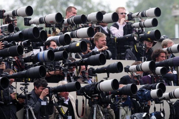 Crowd of press photographers aiming cameras